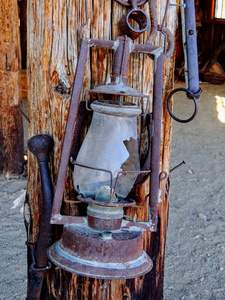 西式生锈古董破碎油灯挂在农场乡村旧灯复古风格挂在木头背景上。