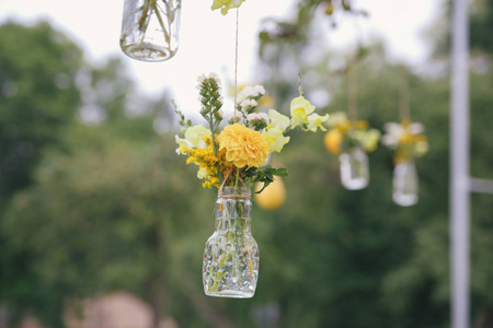 最初的婚礼花装饰，以迷你花瓶和花束的形式悬挂在天花板上