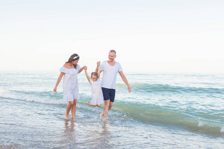爸爸, 妈妈和女儿沿着海滩散步