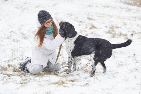 一只狗指针在冬天散步女孩