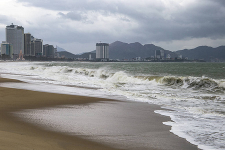 风暴与浪在海滨与城市和山在背景