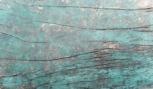 旧的粗糙的蓝色绿色木制表面有裂缝。 文本