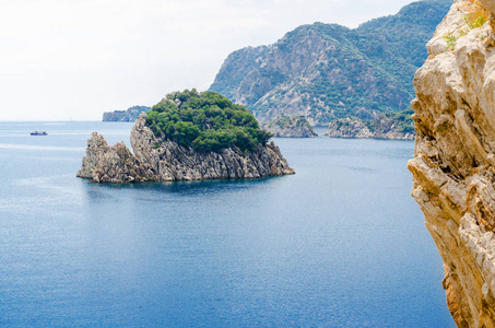 大海中的荒岛和岩石夏天的全景在海湾的群山背景下，蓝色平静的心情在度假，狂野的自然。