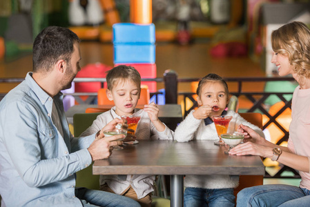 幸福的家庭和两个孩子在咖啡馆吃甜点