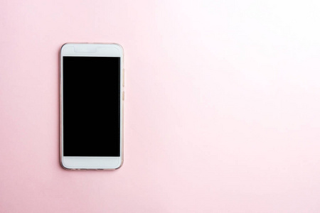 粉红色背景上的白色手机。 复制顶部视图