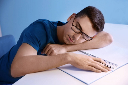 疲倦的学生睡在他的办公桌室内。准备考试