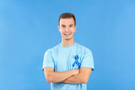 年轻男子身穿 tshirt 与蓝色丝带的颜色背景。前列腺癌认知概念