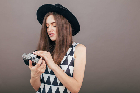 时尚的女性摄影师与复古相机在灰色的墙壁背景。 复制空间图像
