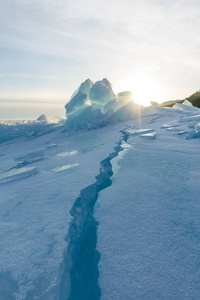 黎明在蓝色的腐殖质的冰湖贝加尔湖在一个下雪的田野在冬天的旅程。