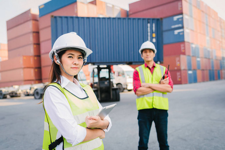 员工和领班以叉车和集装箱货物货运为背景，控制物流出口进口行业的集装箱货物装载。
