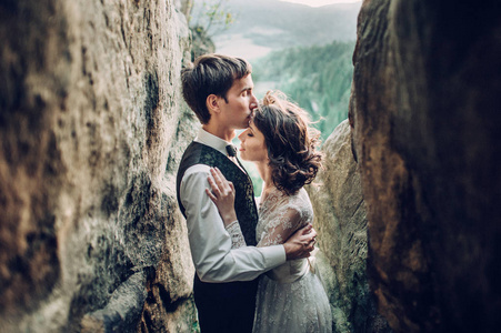 年轻迷人的白种人订婚夫妇拥抱在山景前