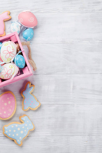 复活节彩色姜饼兔子和鸡蛋在木桌上。 顶视图空间