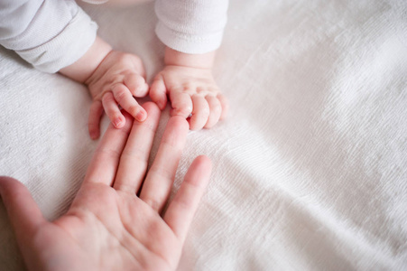 在母亲的手指上的一个初生婴儿的手