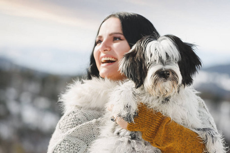 幸福的女人抱着她的西藏猎犬冬天选择性地关注狗