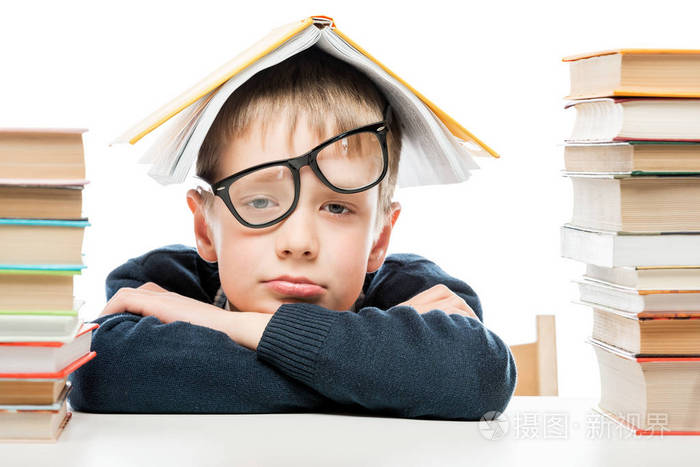 疲惫的小学生和成堆的书籍白色背景下, 关闭