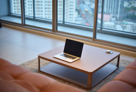 笔记本电脑桌上的现代客厅与空白屏幕