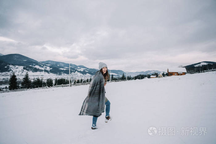 穿绿色毛衣的快乐年轻女孩喜欢下雪. 在雪地里玩得开心.