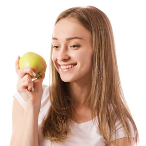 美丽的年轻微笑的妇女拿着一个苹果在她的手