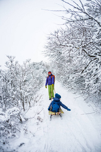 一个女人背着一个孩子在雪橇上