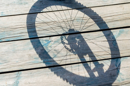 木制背景下自行车车轮的阴影图片