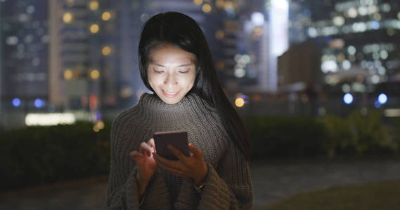 女人晚上用智能手机