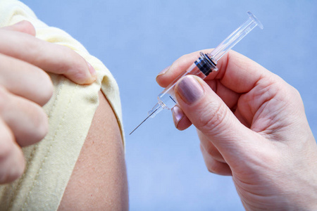 手的医生持有注射器疫苗接种到上臂的 p