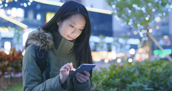 女人晚上在城里用手机