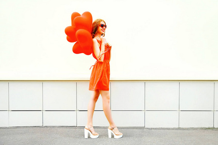 微笑的女人走与红色的空气气球的形状