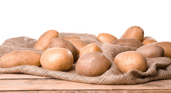 新鲜的土豆在木桌反对白色背景
