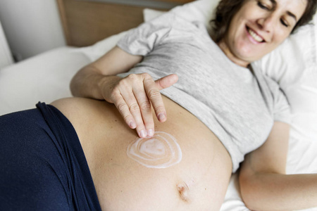 孕妇在婴儿凸点涂护身霜