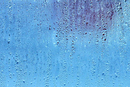 窗玻璃具有冷凝高湿度大液滴流下来的冷色调。 天然水滴背景