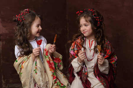 穿着俄罗斯服装的女孩笑着拿着棒棒糖