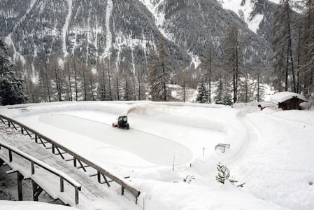 一台滑冰活塞和滑冰机在冬季清洁阿尔卑斯山瑞士的雪。
