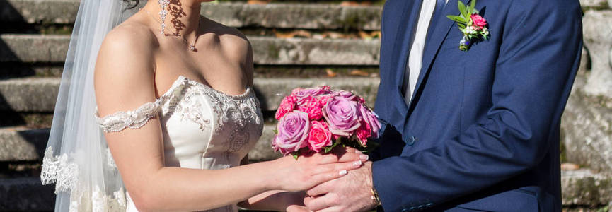 新娘和新郎手持玫瑰结婚花束
