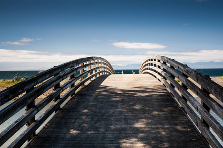 带阴影的木制脚桥通向海洋海滩图片