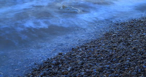 德文郡侏罗纪海岸的鹅卵石滩波浪模糊