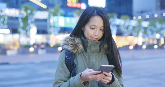 城市里晚上用手机的女人