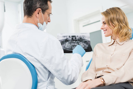 在现代诊所咨询牙医的妇女看X光