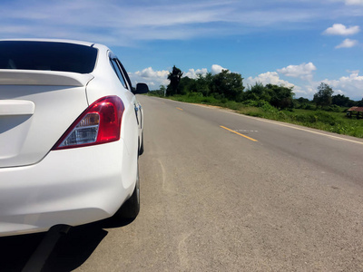 汽车在道路上，从后面向右看。白色汽车。