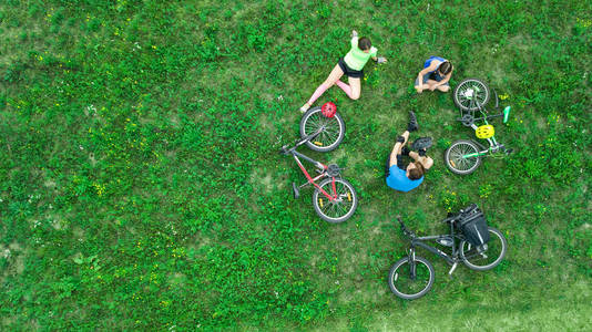 家庭自行车户外自行车空中景观从上面快乐积极的父母与孩子玩得开心和放松的草地家庭运动和健身周末