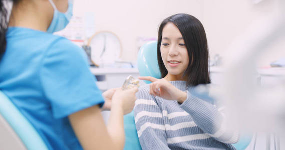牙科医生向牙科诊所的病人解释牙齿的种植