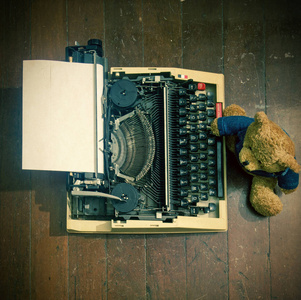老泰迪熊在复古打字机图片