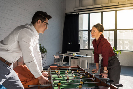 年轻的商业伙伴在现代办公室踢桌球