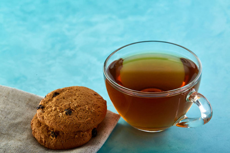 玻璃杯茶和燕麦巧克力饼干特写蓝色背景