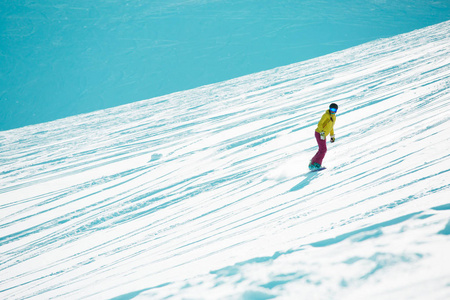 从山坡上戴头盔和面具滑雪运动女孩的形象