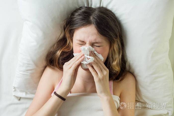 感冒季节, 流鼻涕.生病的女孩在床上打喷嚏的手帕在卧室里