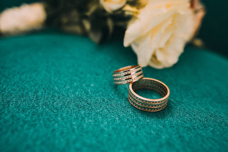 漂亮的结婚戒指躺在木质的表面背景下的一束鲜花