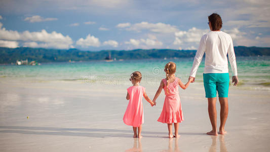 两个小女孩和年轻父亲的背影