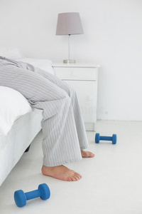 一个穿着睡衣的年轻人躺在床上的低矮部分