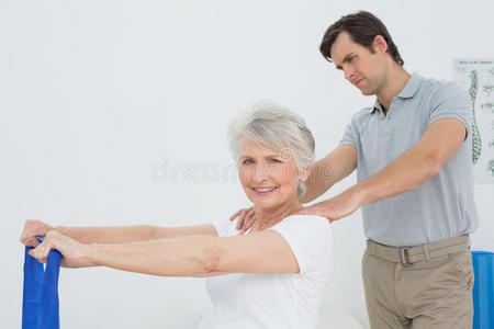 男性治疗师协助老年女性锻炼